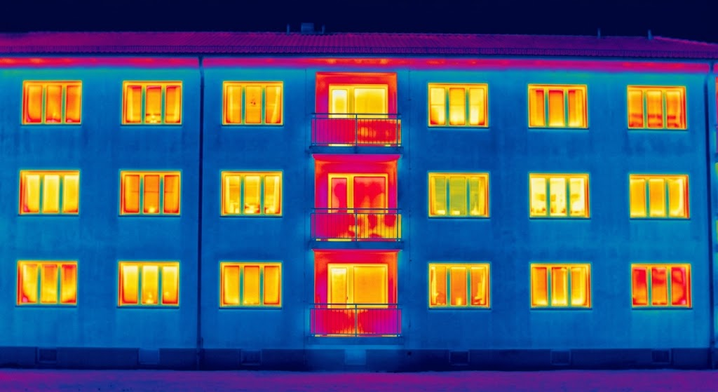 Immagine termografica (termografia) della facciata di un condominio a Torino, che evidenzia la dispersione termica (zone rosse e arancioni) dalle finestre e dai balconi, fondamentale per la diagnosi energetica e il nuovo APE 2026 Torino