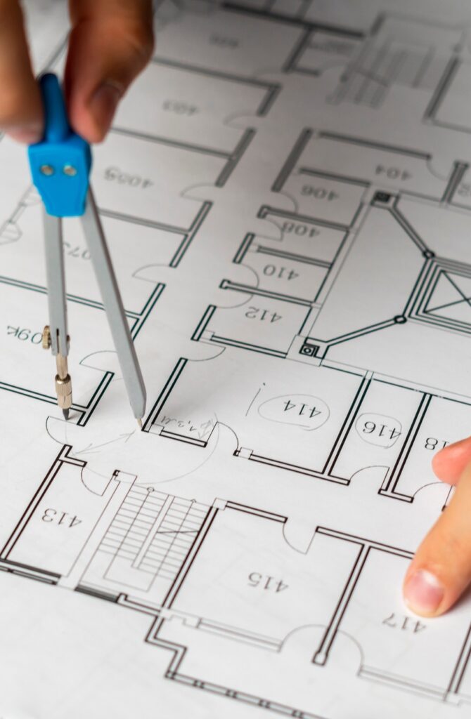 engineer sketching building project on a blueprint with a pencil b