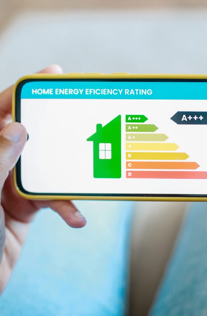 Home energy performance: Hands hold mobile phone look at house efficiency rating app